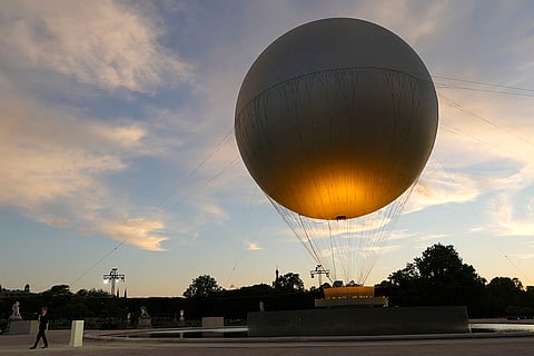 Leon Marchand, carries a lantern containing the Olympic flame as the cauldron is slowly extinguished on the final day of the 2024 Olympics